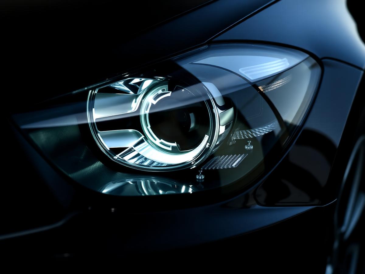 Close-up of a clear, restored headlight on a dark vehicle